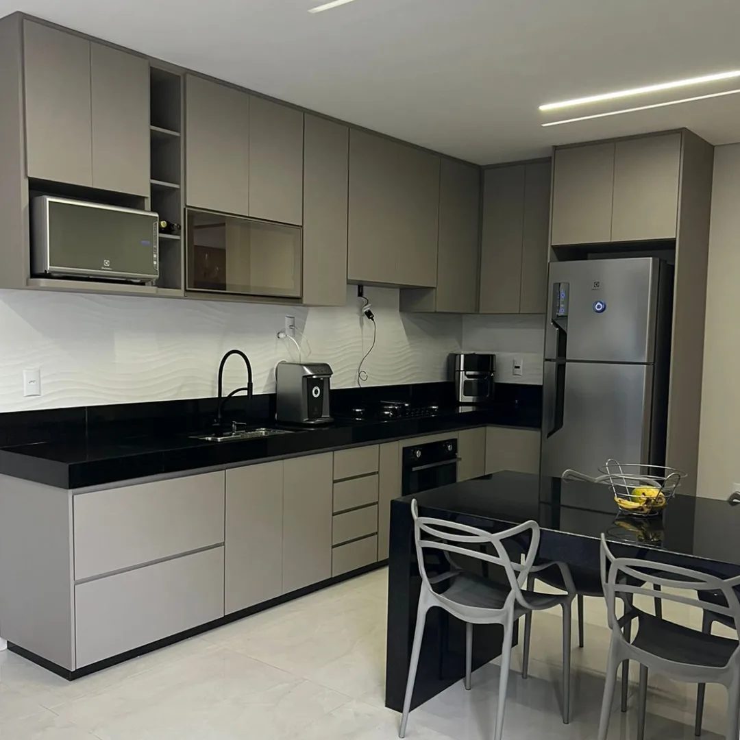 Cozinha fendi com bancada preta e mesa de refeição integrada